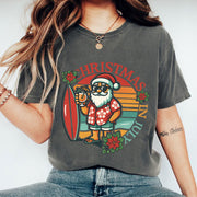 Festive Christmas in July Graphic Tee - Surfer Santa Design, Fun Holiday Style, Perfect for Summer Celebrations, Unisex Fit
 - 1