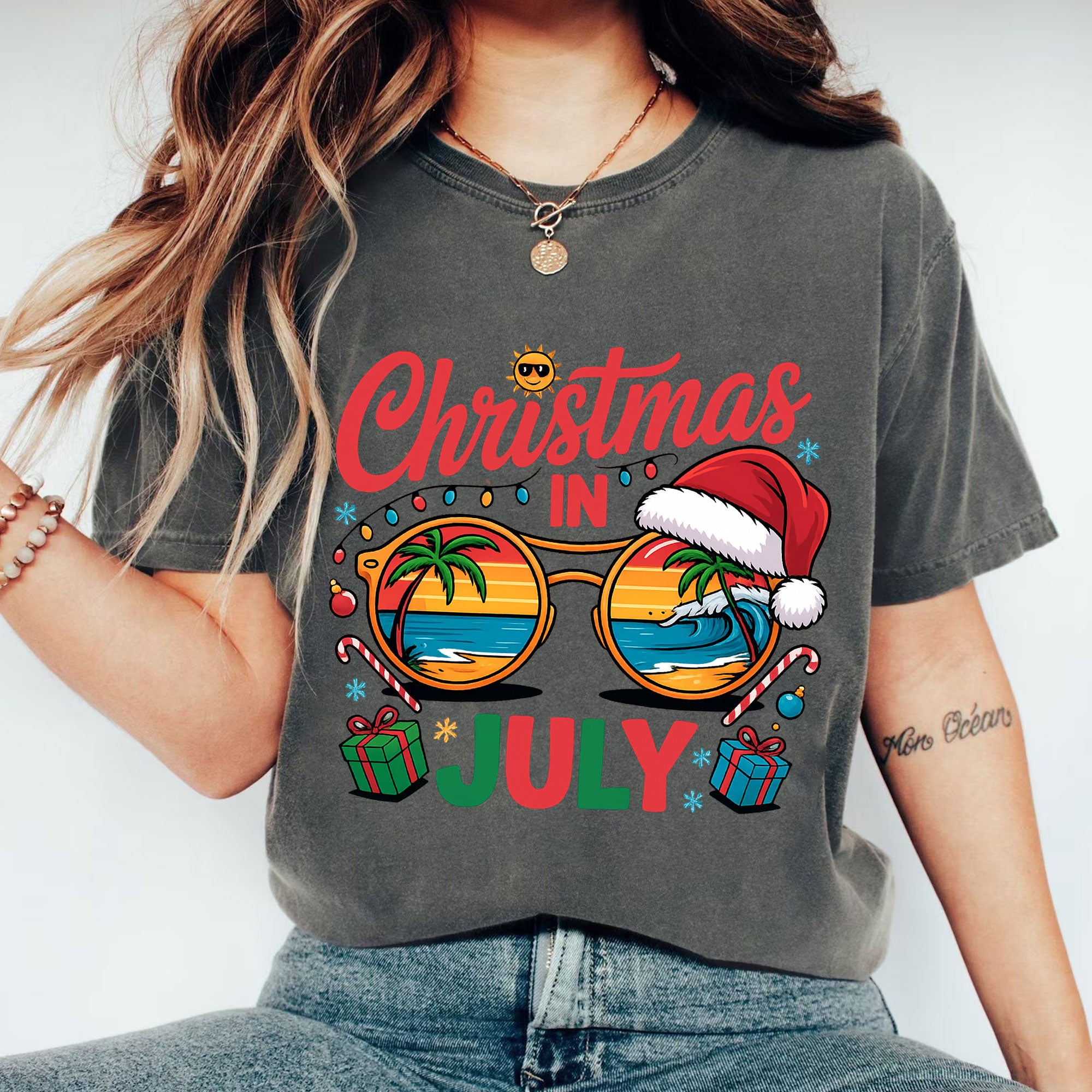 Festive Christmas in July Women's T-Shirt: Fun Holiday Graphic Tee Featuring Beach Scene, Sunglasses, and Santa Hat Design
 - 1