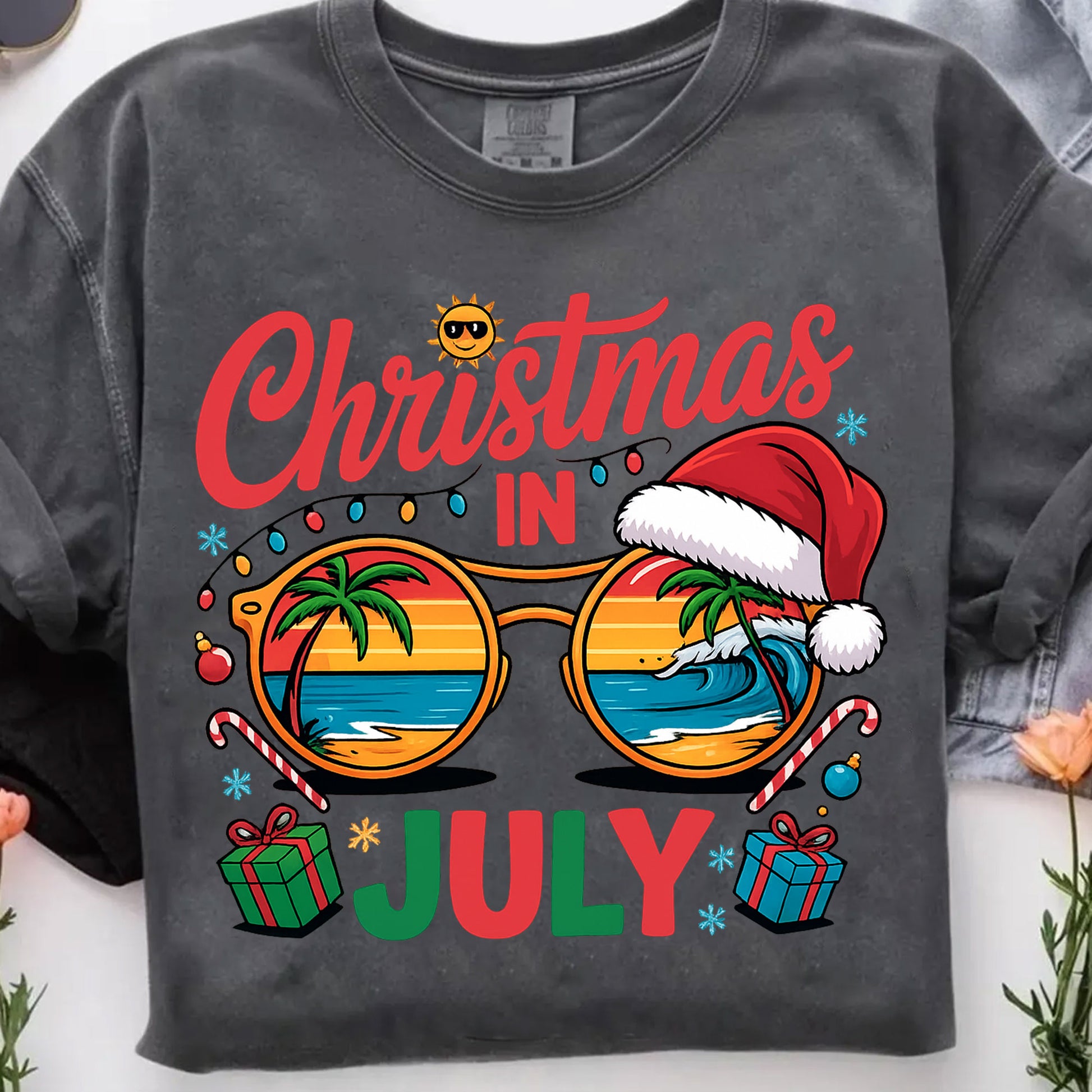 Festive Christmas in July Women's T-Shirt: Fun Holiday Graphic Tee Featuring Beach Scene, Sunglasses, and Santa Hat Design
 - 7
