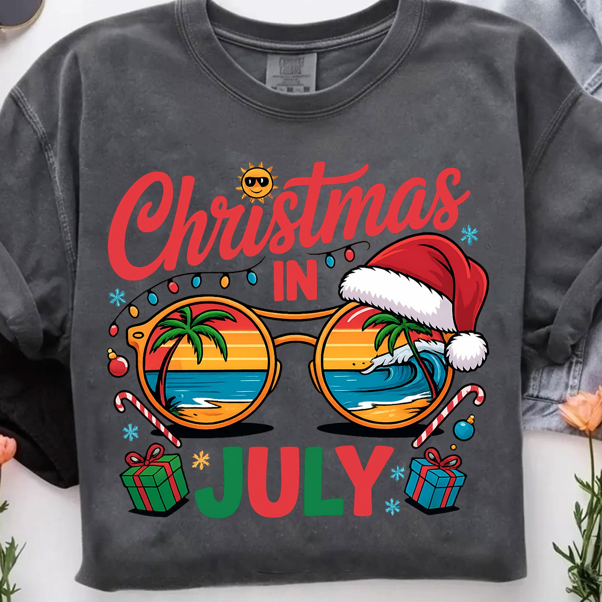 Festive Christmas in July Women's T-Shirt: Fun Holiday Graphic Tee Featuring Beach Scene, Sunglasses, and Santa Hat Design
 - 7