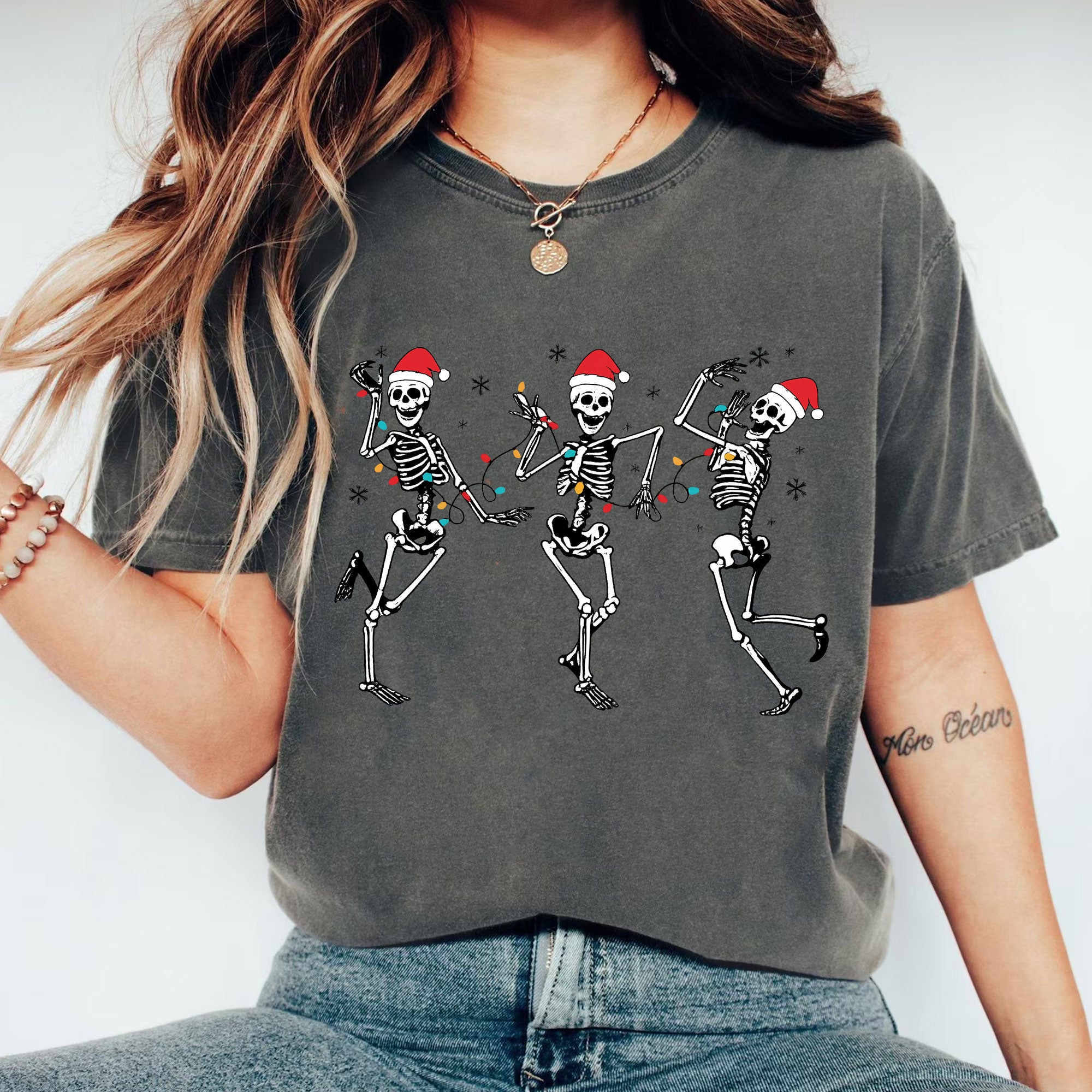 Festive Dancing Skeletons Christmas T-Shirt – Funny Holiday Skeleton Graphic Tee with Santa Hats for Women – Unique Christmas Apparel
 - 1